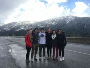 Friends smiling on snowy mountain road