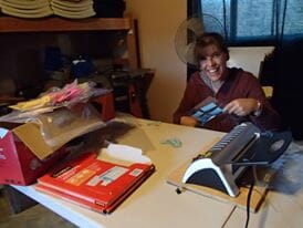 Person laminating documents in a workspace.