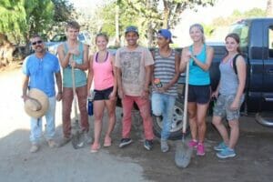 Group of young volunteers with shovels outdoors.