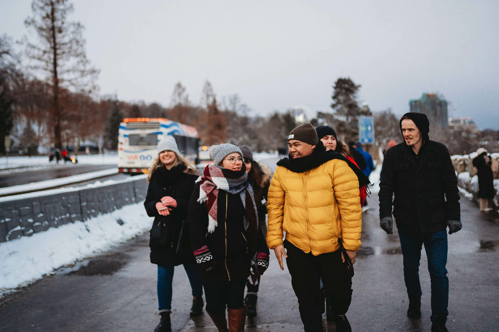 Group walking on snowy path, smiling