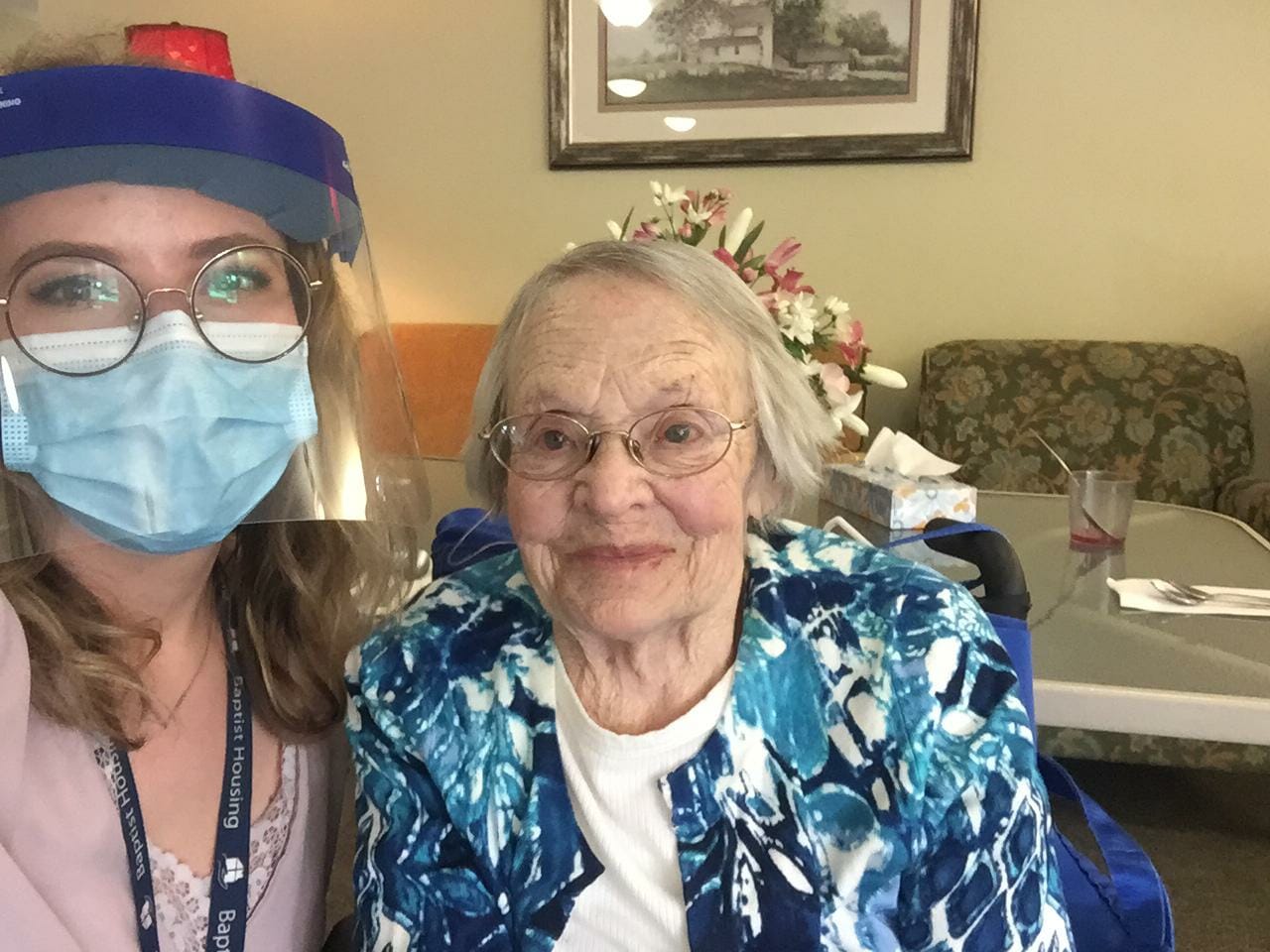 Nurse and elderly woman smiling at the camera