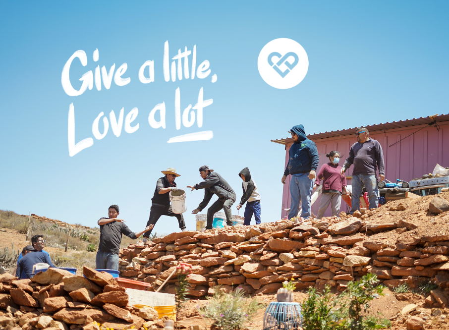 Volunteers building stone wall, teamwork and community support.
