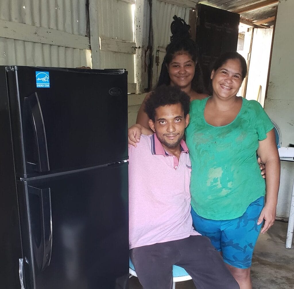 Smiling family beside a new refrigerator.