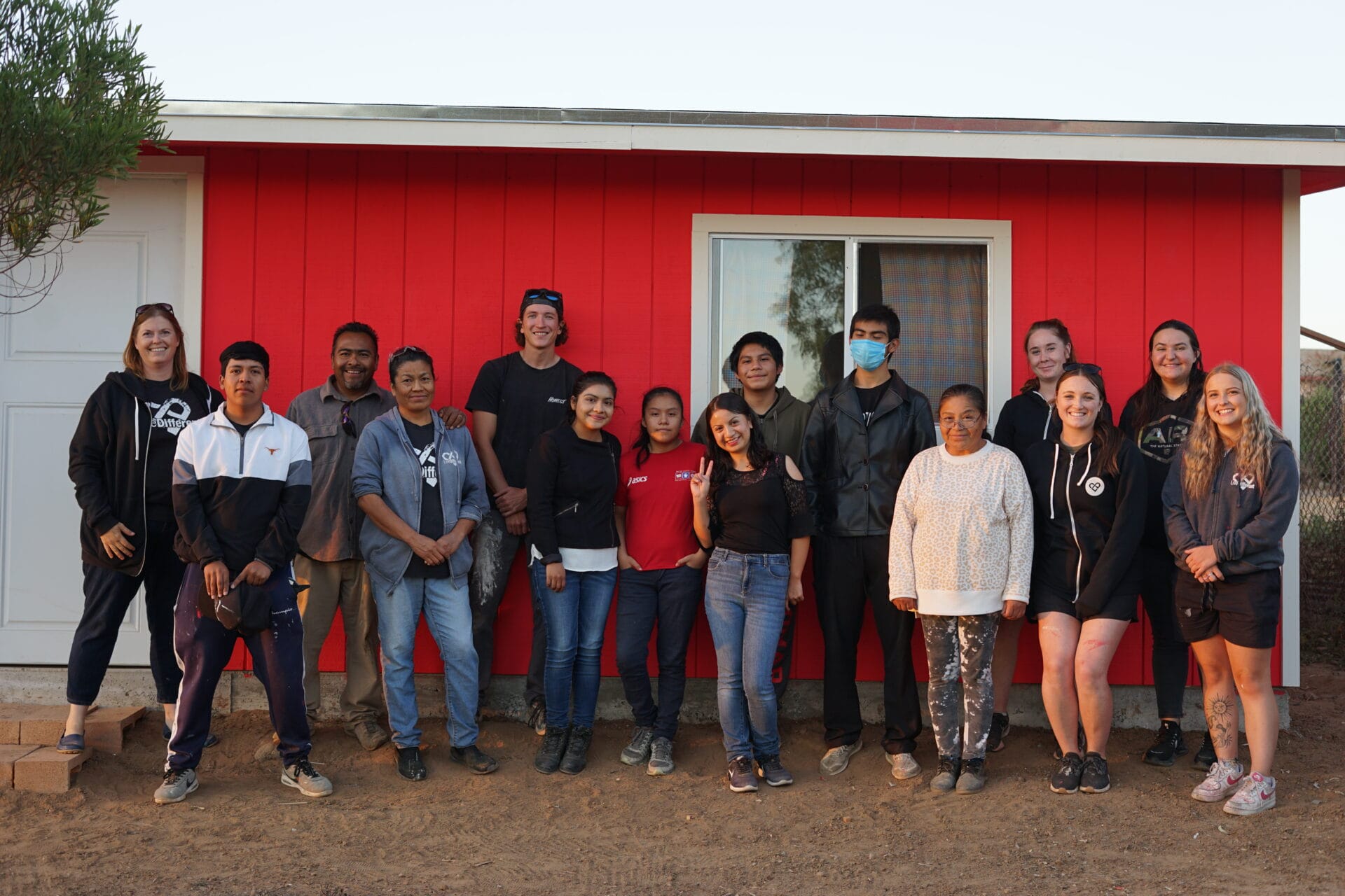 Group photo in front of red house