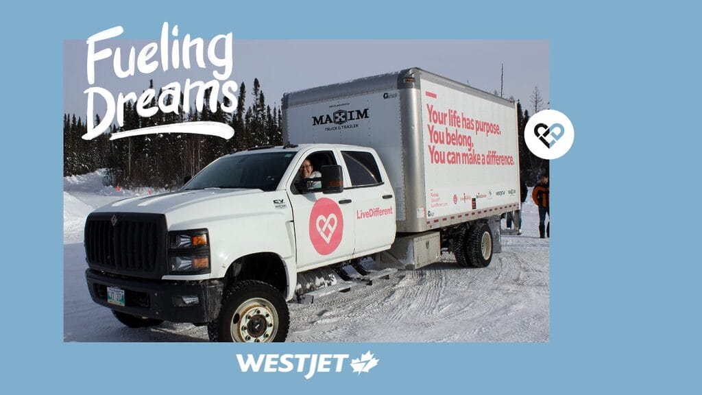 Truck with inspiring message in snowy landscape.