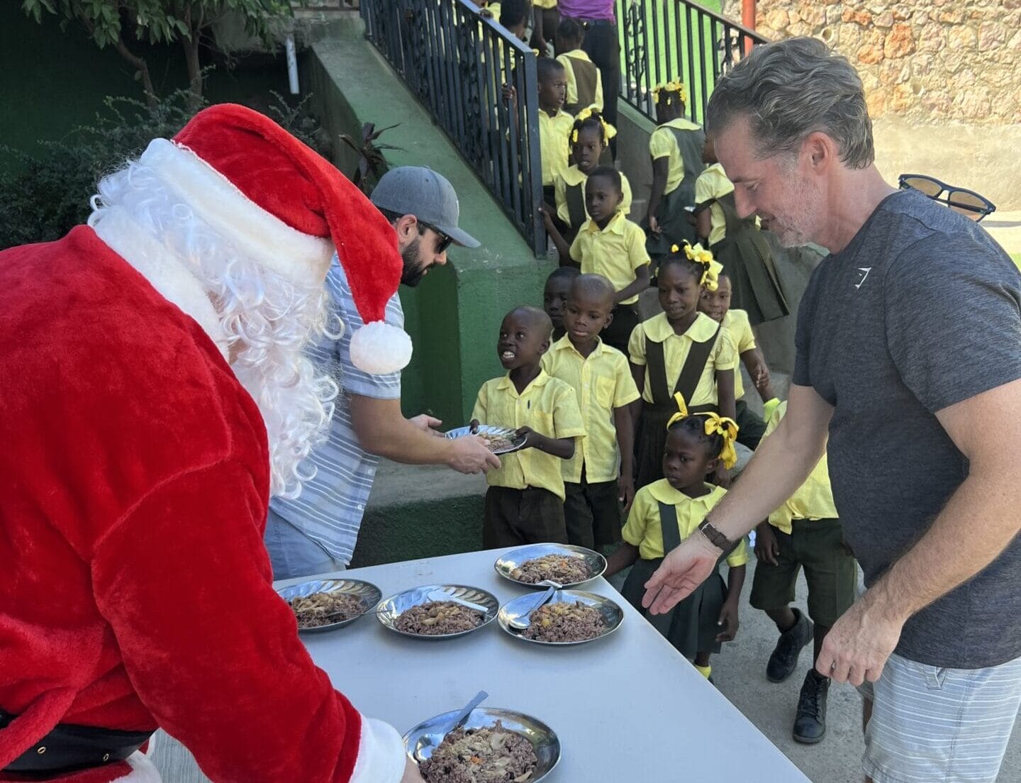 Santa and volunteers serving food to schoolchildren.