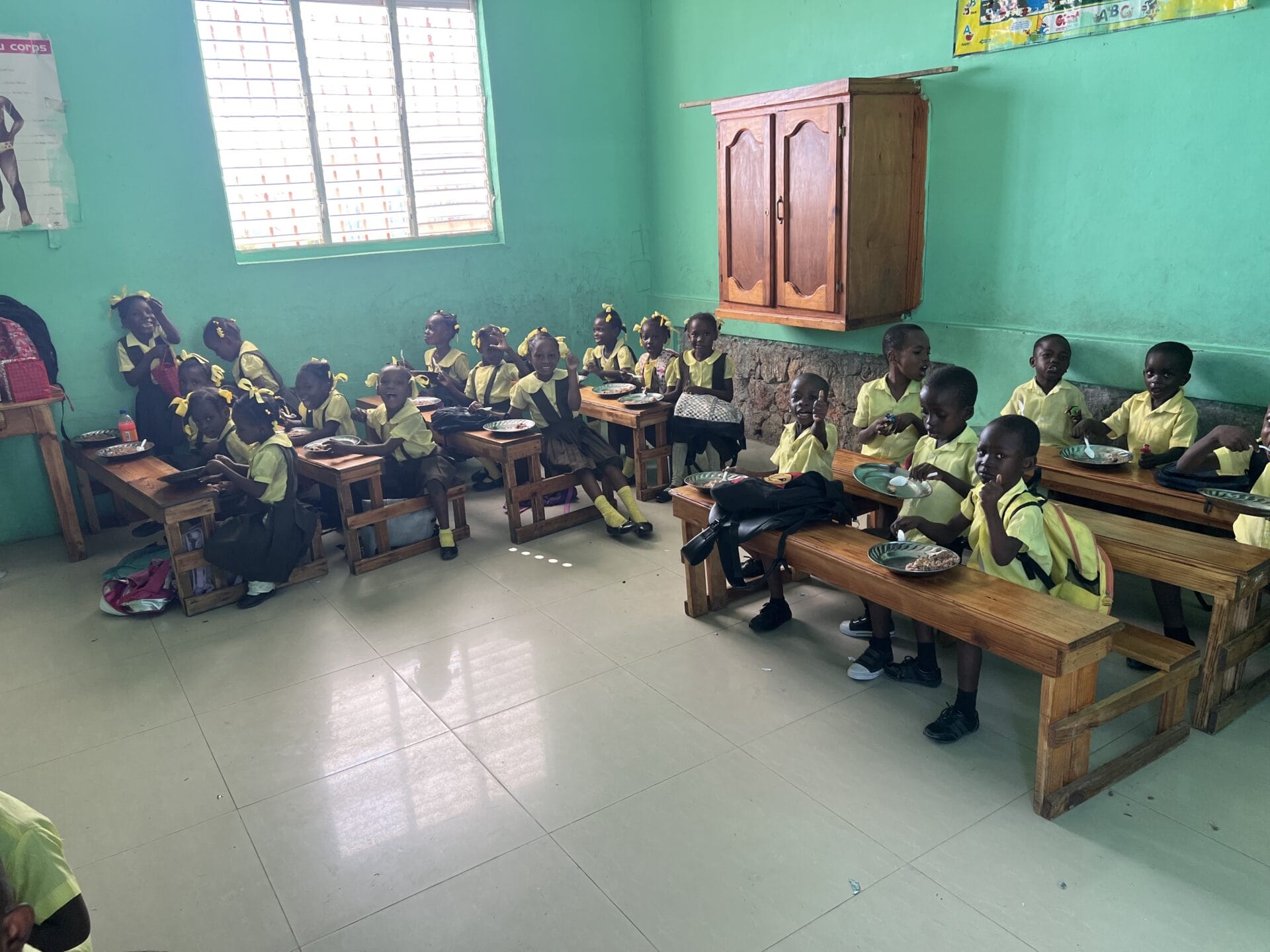 Children in classroom eating a meal together.