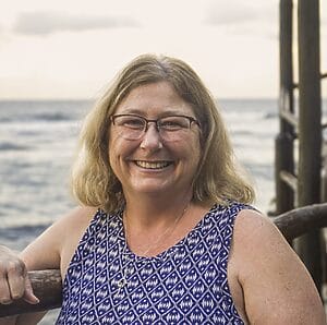 Smiling woman by the ocean.