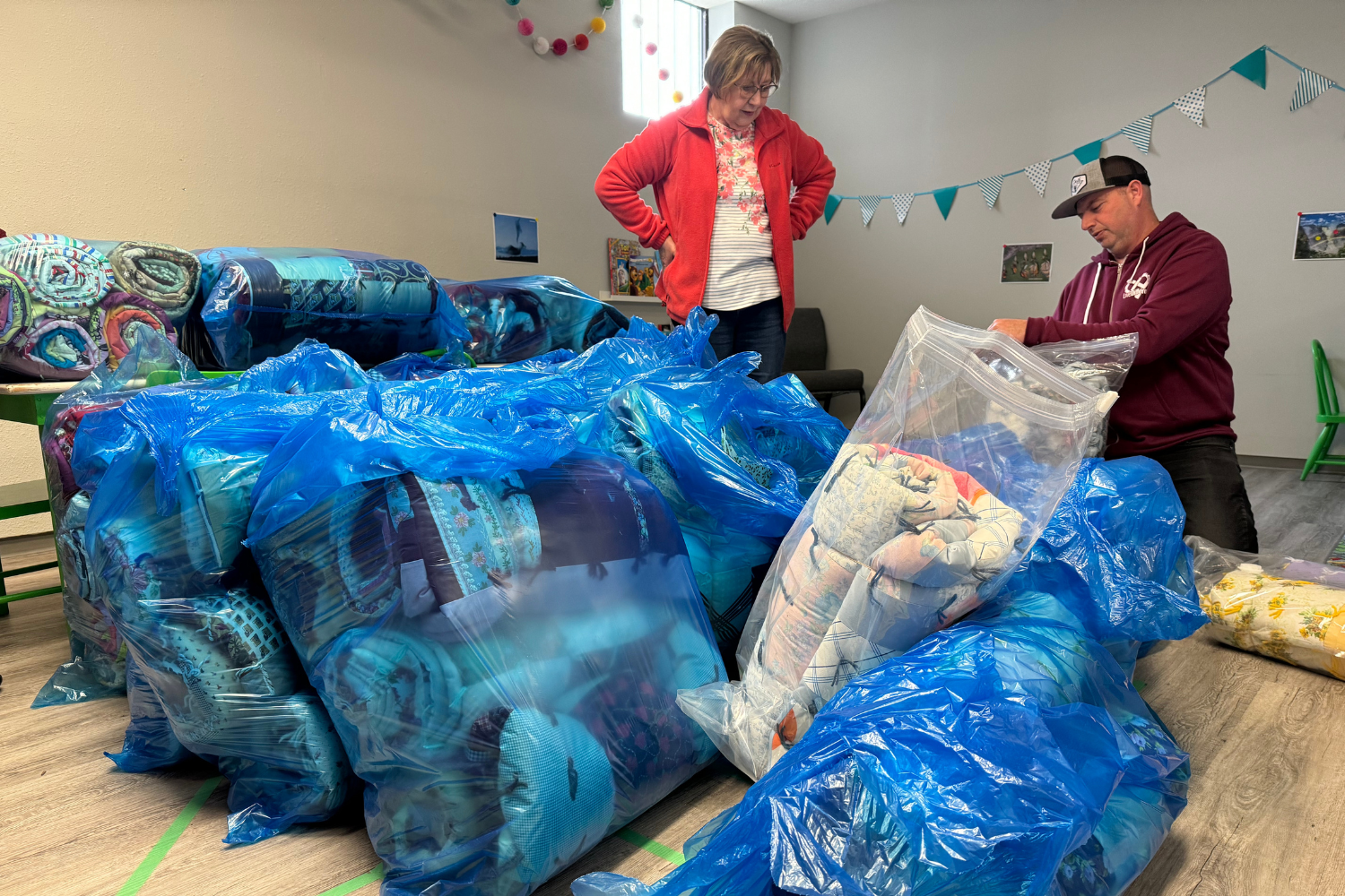 Volunteers sorting blue bags of quilts.