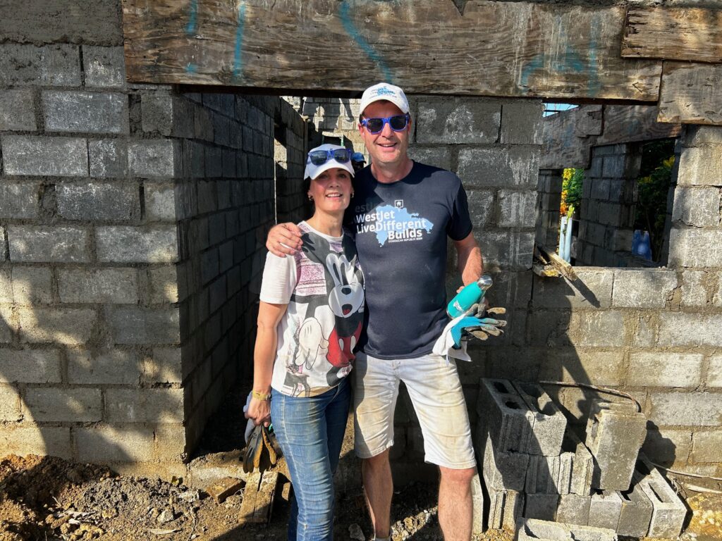 Two people building a concrete structure together.